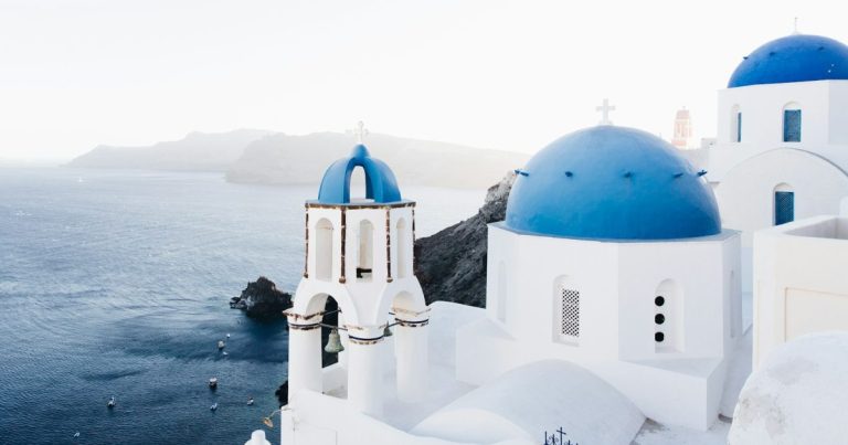 Kék kupolás fehér templomok Oia falujában, Santorini szigetén
