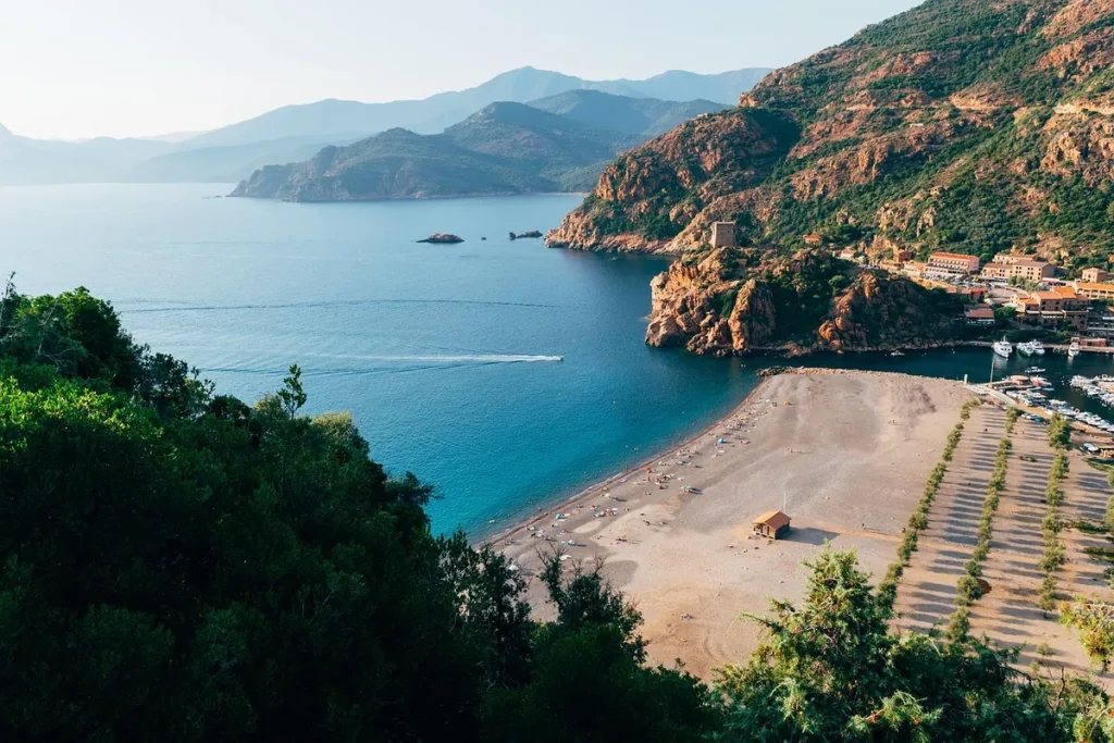 Öböl és strand Korzika nyugati partján, hegyekkel a háttérben