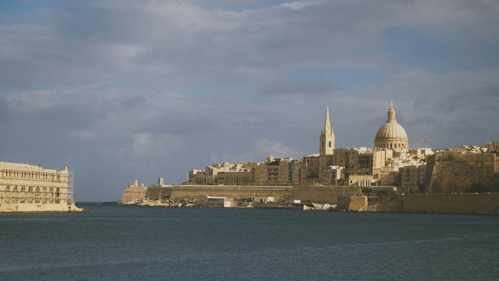 Valletta óvárosa a Karmelita-templom kupolájával és a Szent Pál-templom tornyával, a Marsamxett-kikötő felől