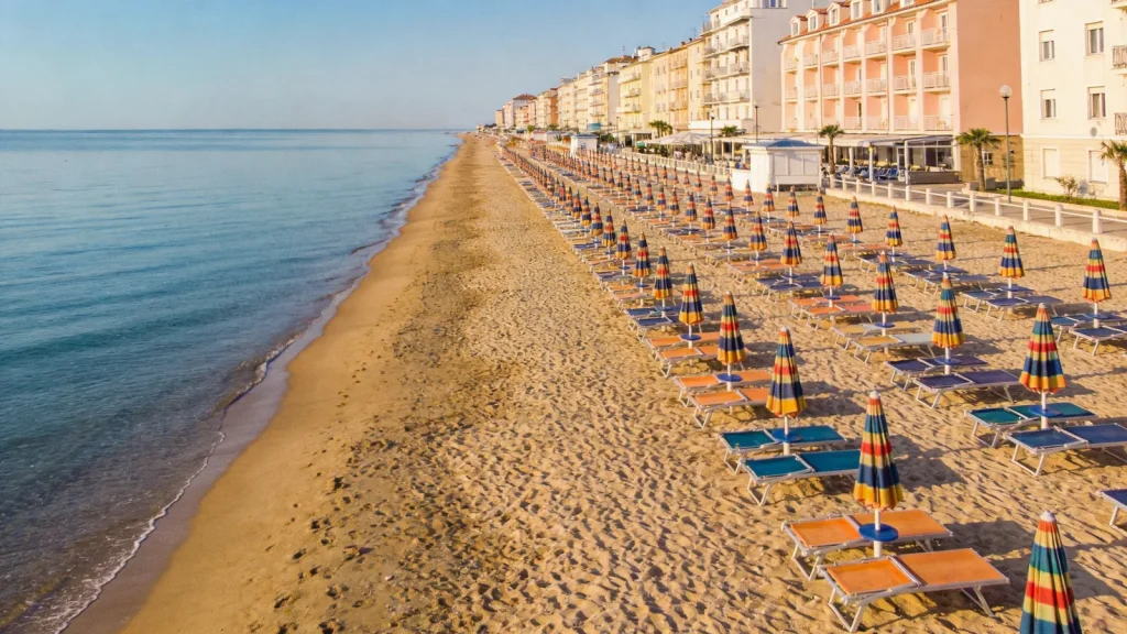 Széles homokos adriai strand színes napernyőkkel Rimini környékén