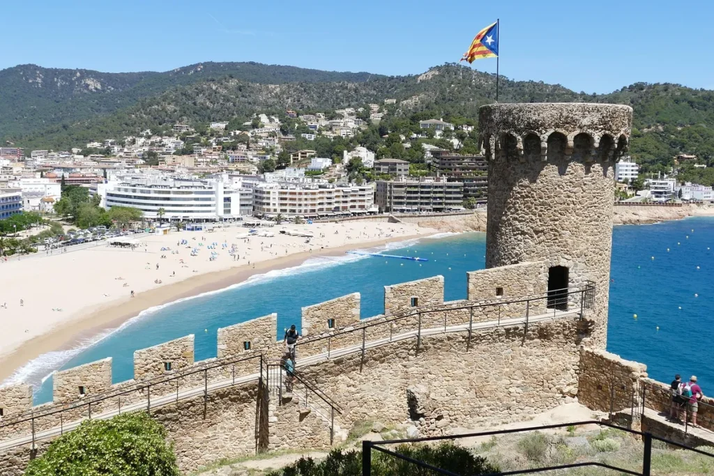 Tossa de Mar óvárosának tornya és homokos strandja