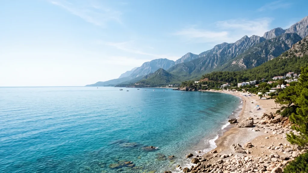 Türkizkék tengerpart Antalya mellett, fenyves hegyekkel és homokos stranddal